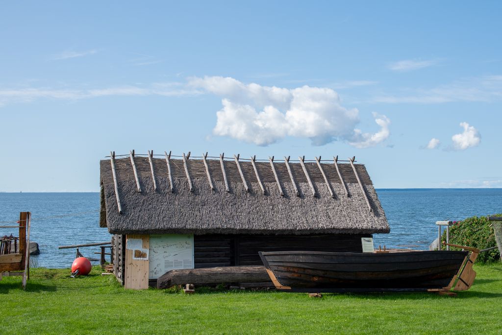 A traditional fisherman hut with a thatched roof, located beside the Baltic Sea in Pringi, Estonia.