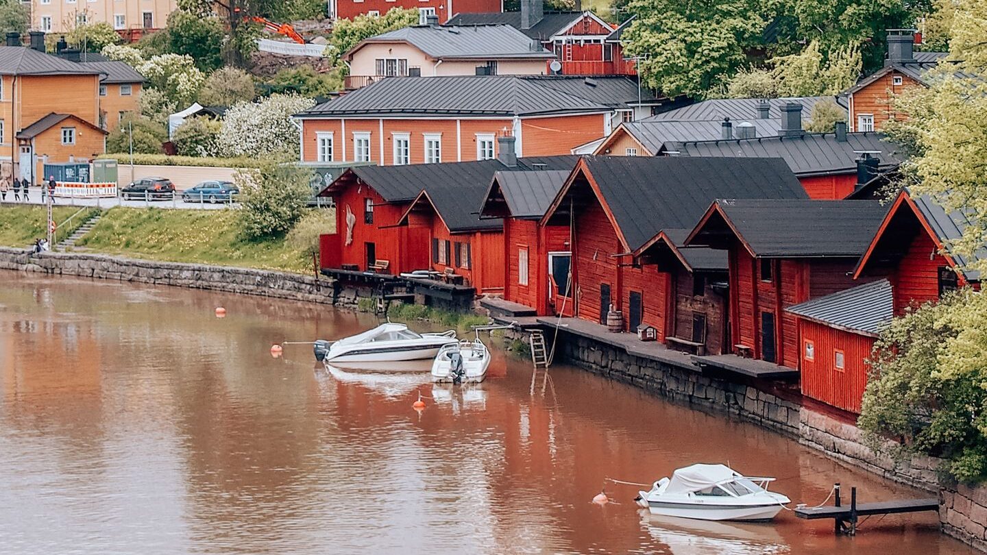 Charming riverside scene with colorful wooden houses and church in Porvoo, Finland.
