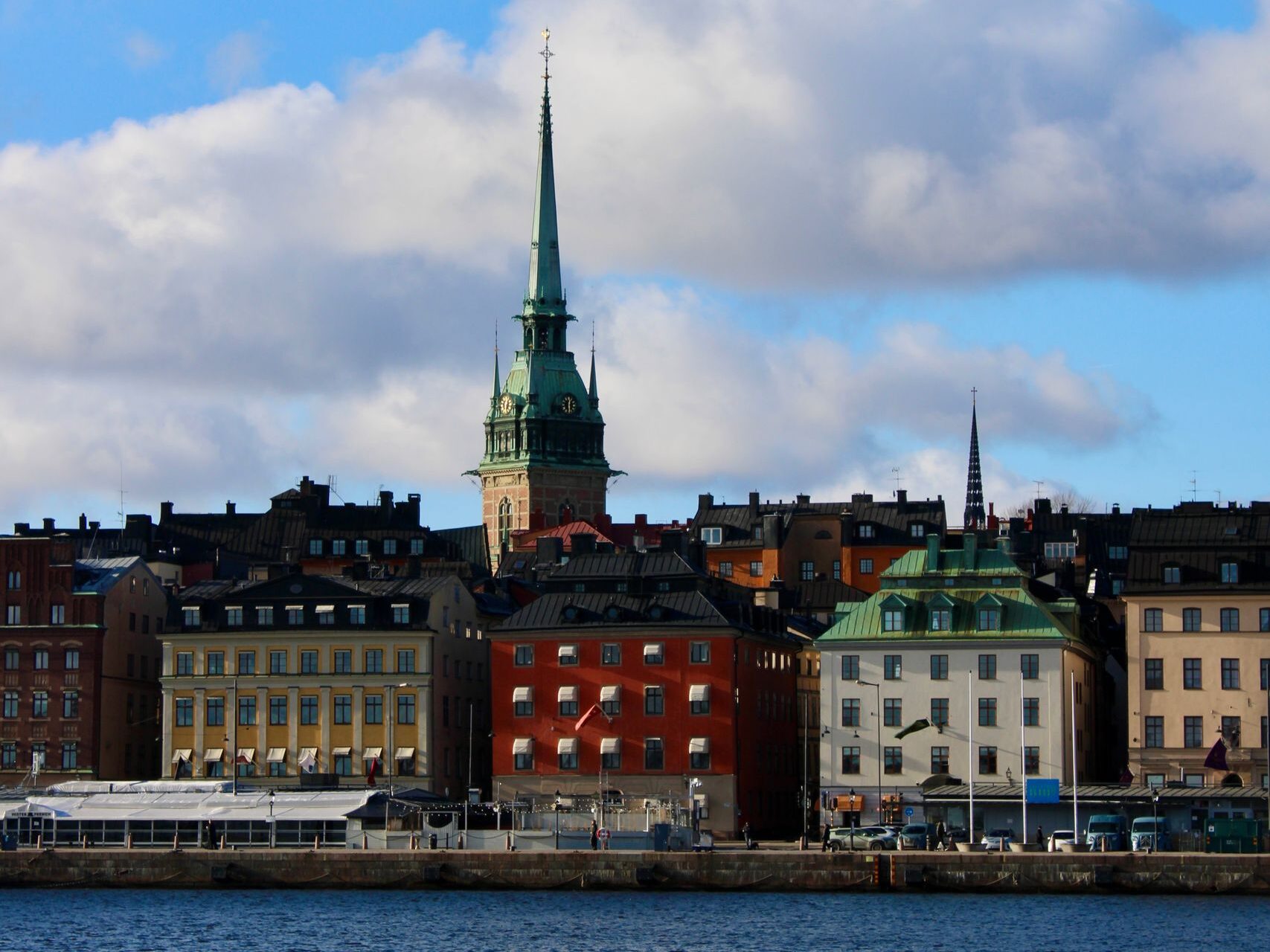 Charming waterfront view of Stockholm's Old Town with historic buildings under a clear blue sky.